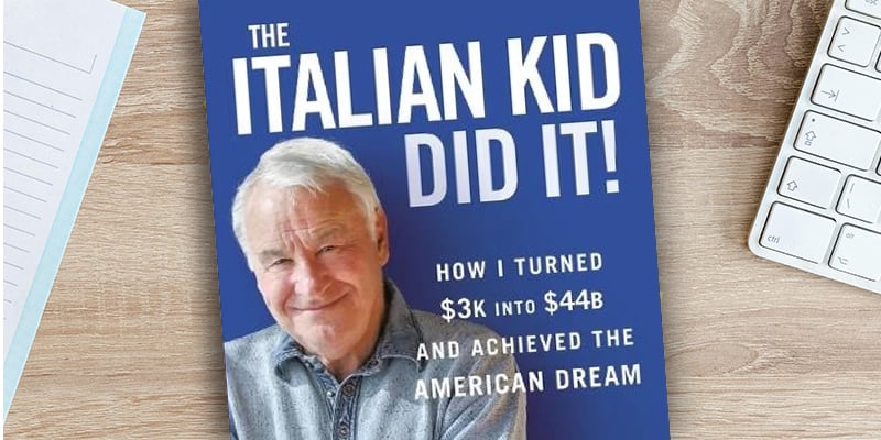 Tom Golisano's book The Italian Kid Did It! sitting on a desk with a keyboard and notebook