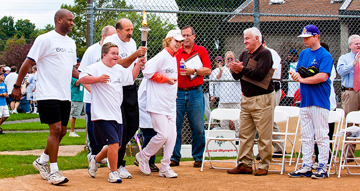 Tom Golisano cheers on Special Oympics Athletes during the torch run.