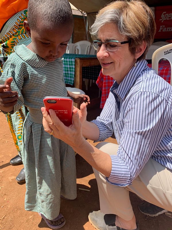 Ann Costello showing a Kenyan child a smartphone.