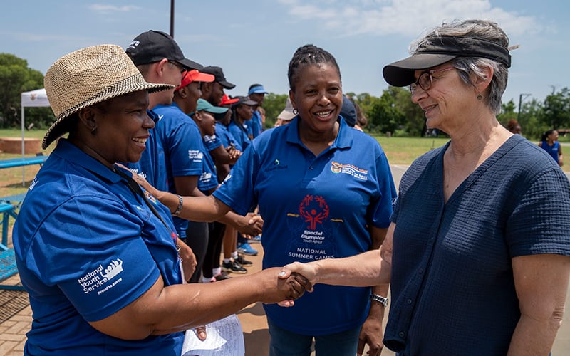 Ann Costello greeting several South African women at a Special Olympics event.