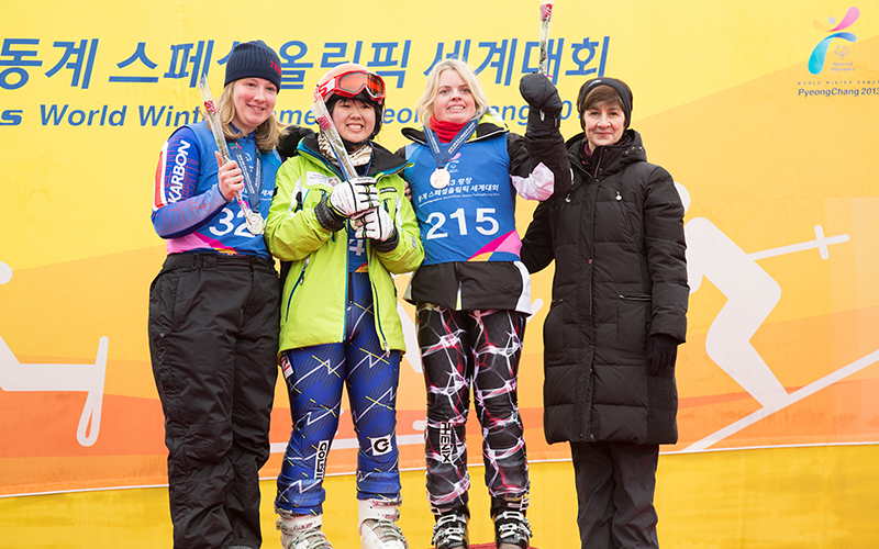 Ann Costello with athletes on the winners podium at the Special Olympics