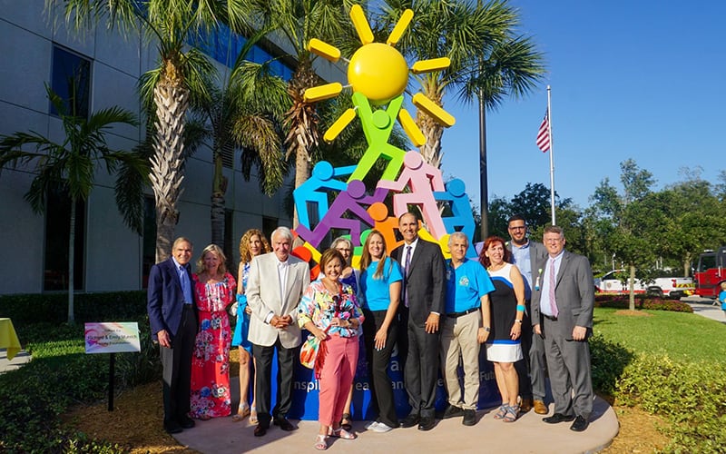Tom Golisano posing with a group of people at the Golisano Children's Hospital of Southwest Florida's five year celebration.