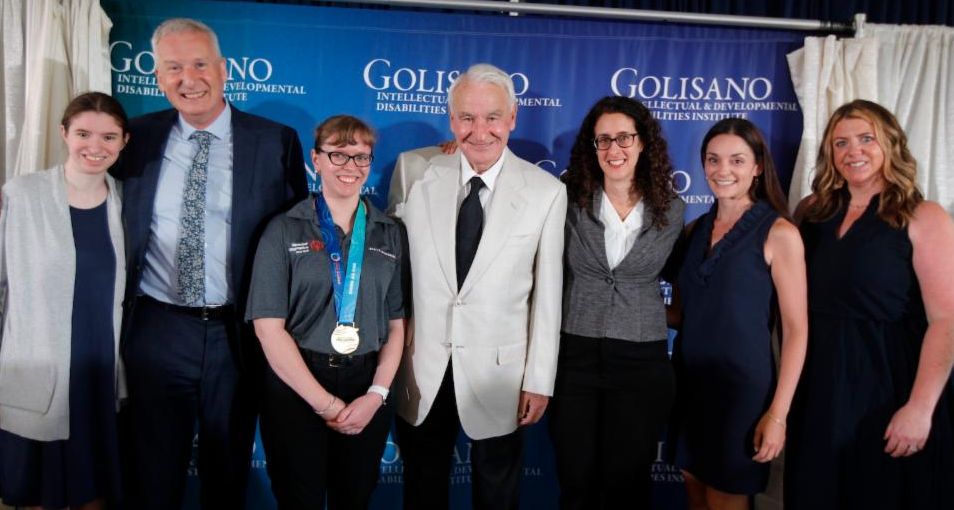 Tom Golisano, Erica Dayton, and John Foxe posing with a group of Special Olympics athletes