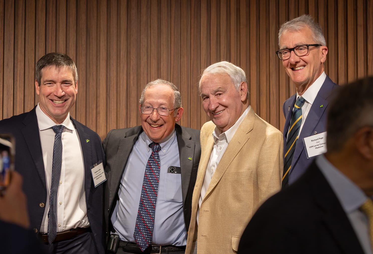 Tom Golisano poses for a photograph with three other people.